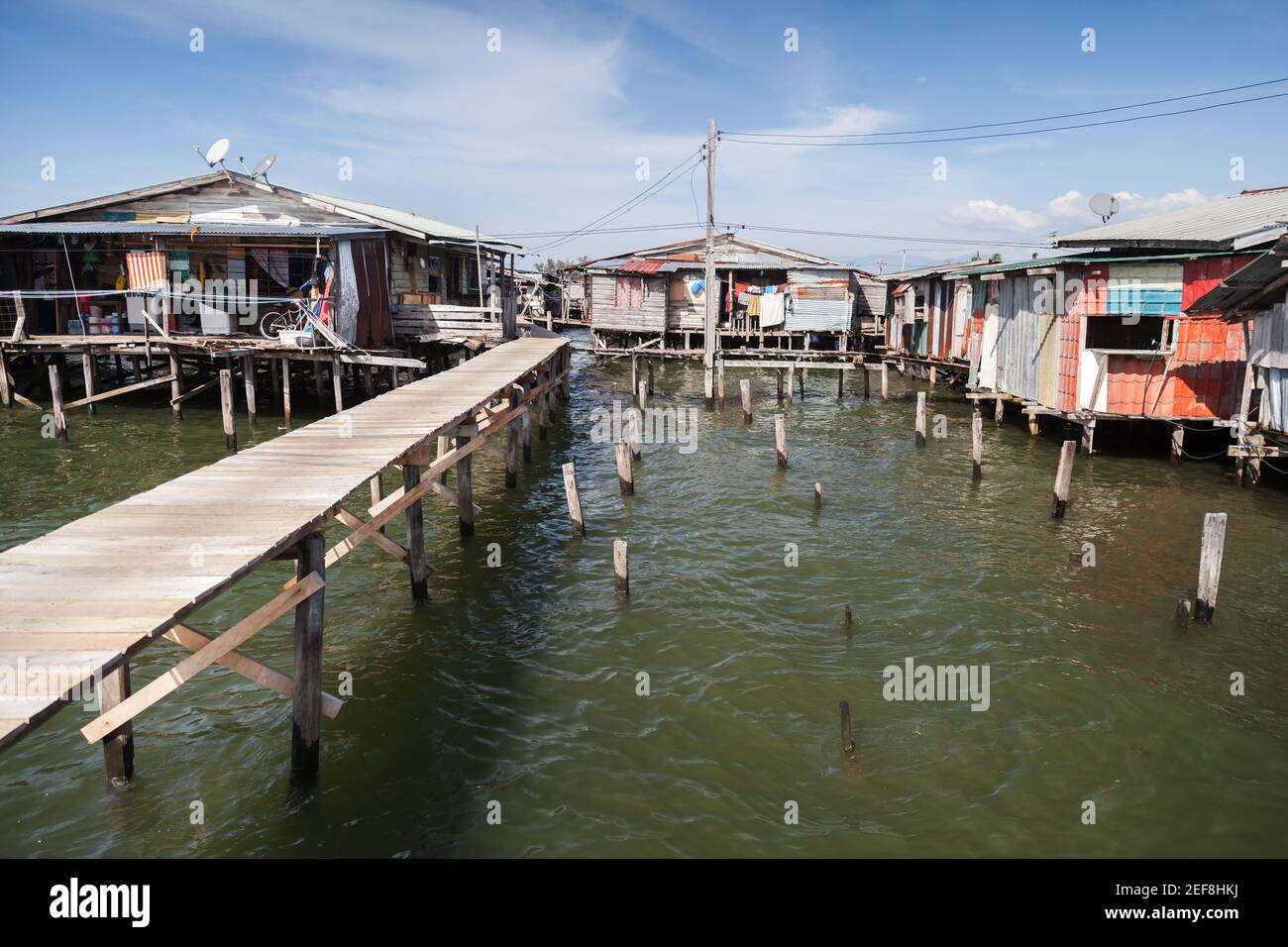 Vue sur la côte du quartier pauvre de Kota Kinabalu, Malaisie. Petites maisons en bois et passerelles sur pilotis Banque D'Images
