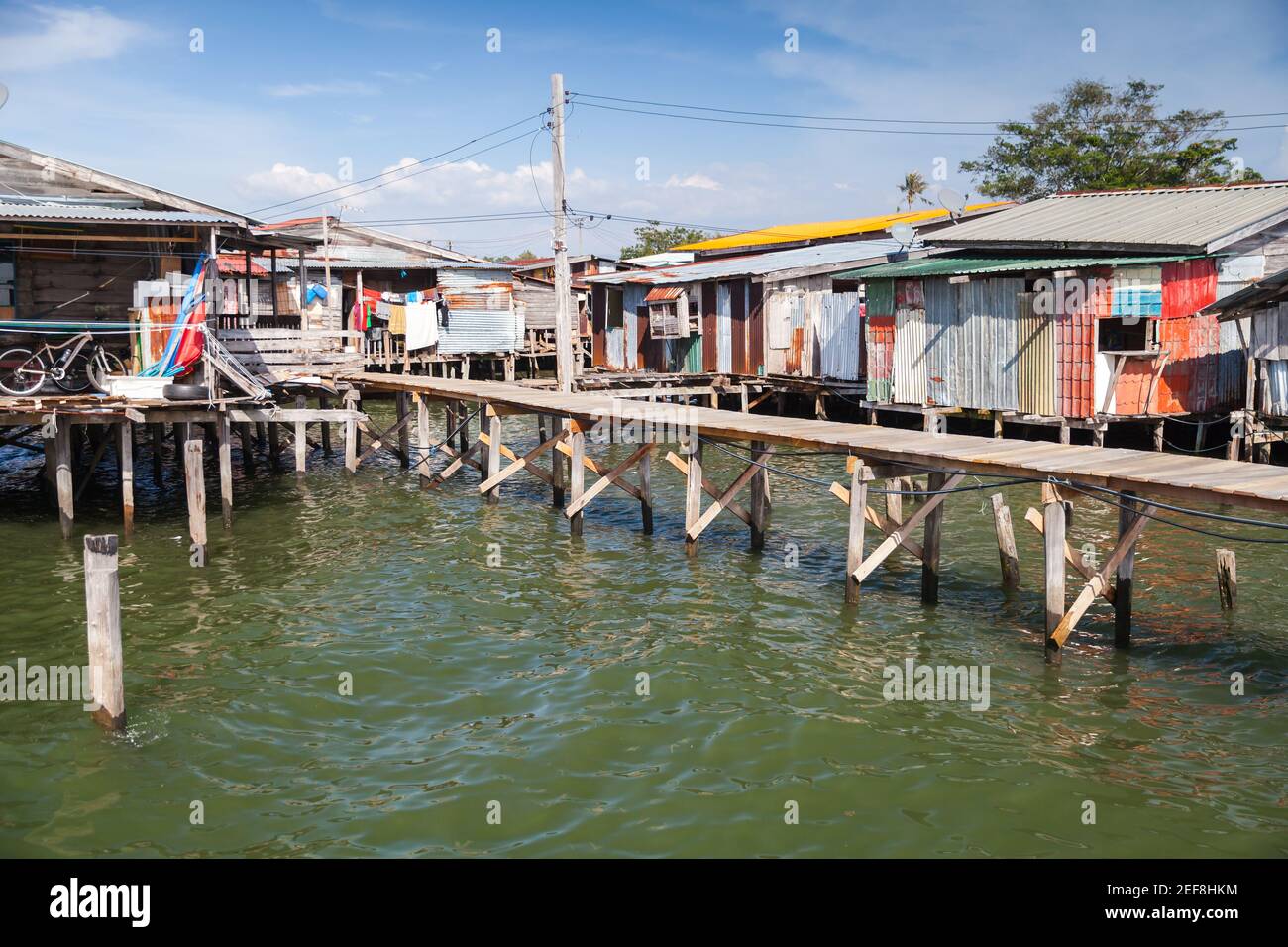 Vue sur la côte du quartier pauvre de Kota Kinabalu, Malaisie. Petites maisons de séjour et passerelles sur pilotis Banque D'Images