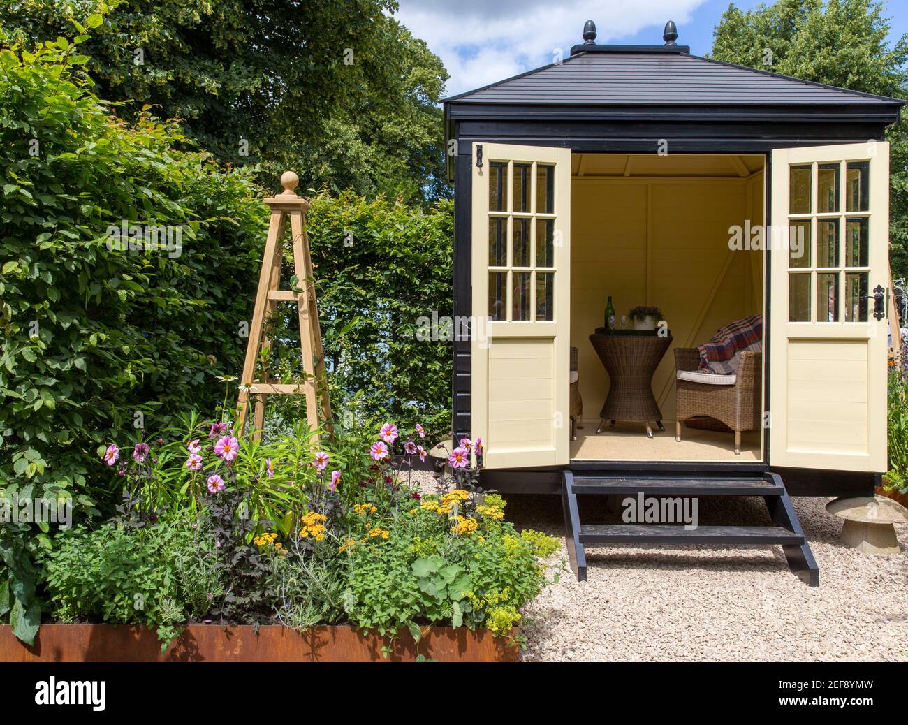 Un petit jardin de cottage anglais avec Summerhouse Shepherds Hut dedans jardin de gravier - travail à la maison bureau - lit surélevé Frontière florale - Londres Royaume-Uni Banque D'Images