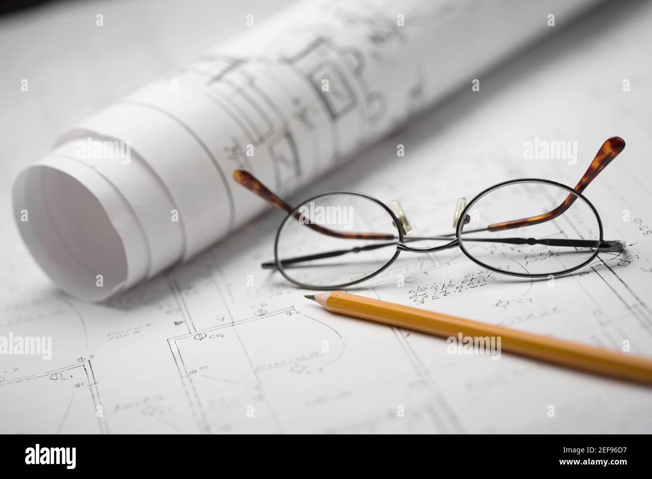 Gros plan d'un crayon et de lunettes sur une feuille de papier Banque D'Images