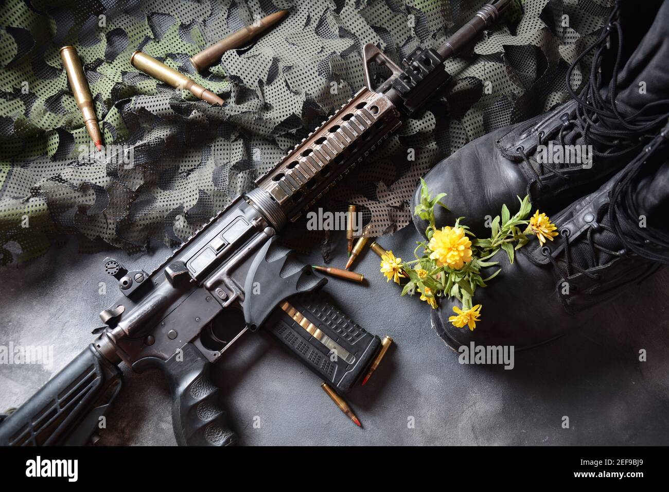 Jour du souvenir israélien Yom Ha'zikaron. Ensemble militaire de l'armée , bottes de soldat en cuir noir, arme, munitions et fleurs jaunes . Guerre et paix Banque D'Images