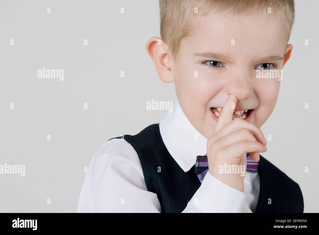 Gros plan d'un garçon avec son doigt dans le nez Banque D'Images