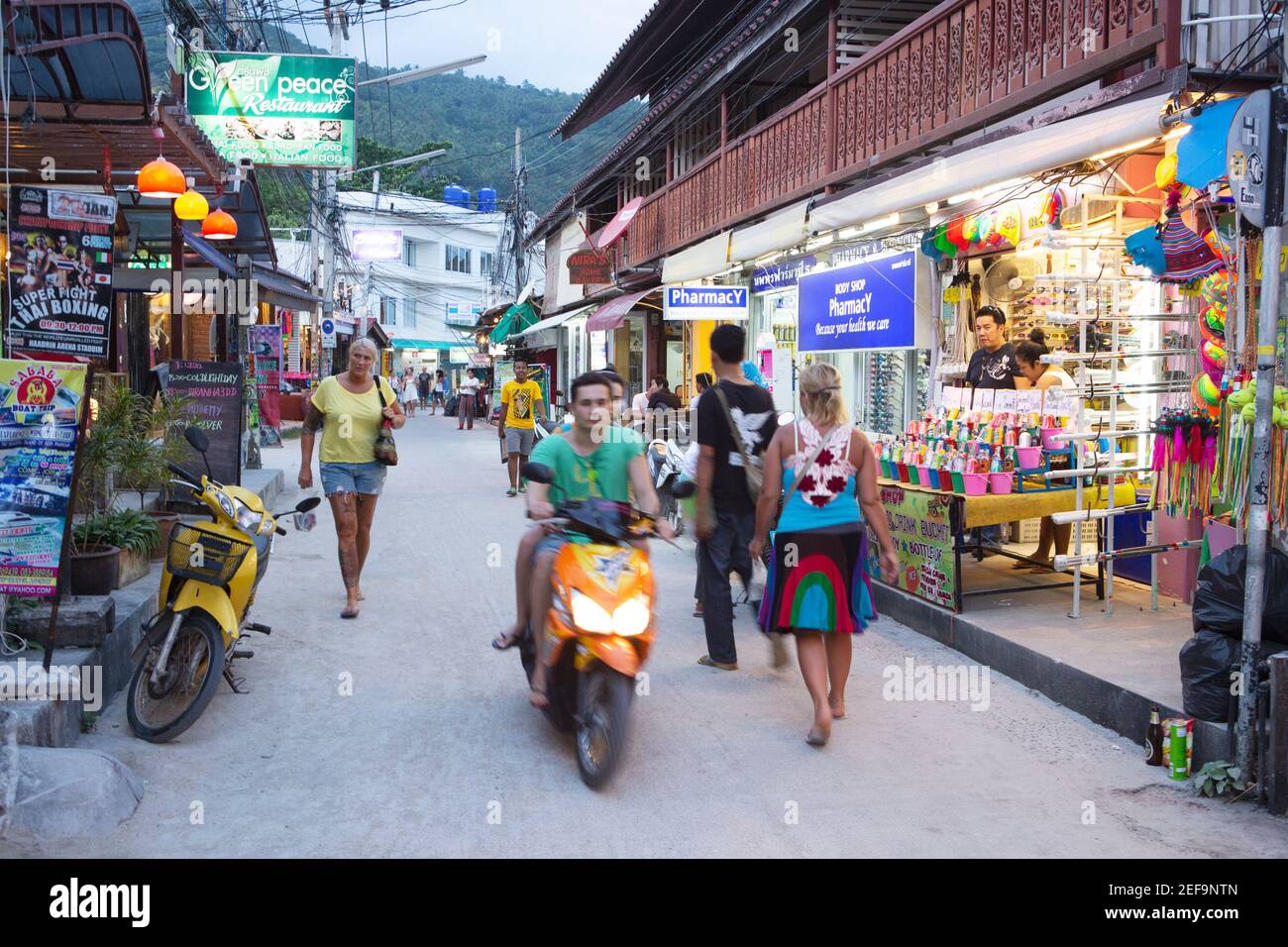 Touristes dans une rue arrière animée bordée de boutiques, bars, restaurants et magasins, île de Koh Phangan, Thaïlande, Asie du Sud-est Banque D'Images