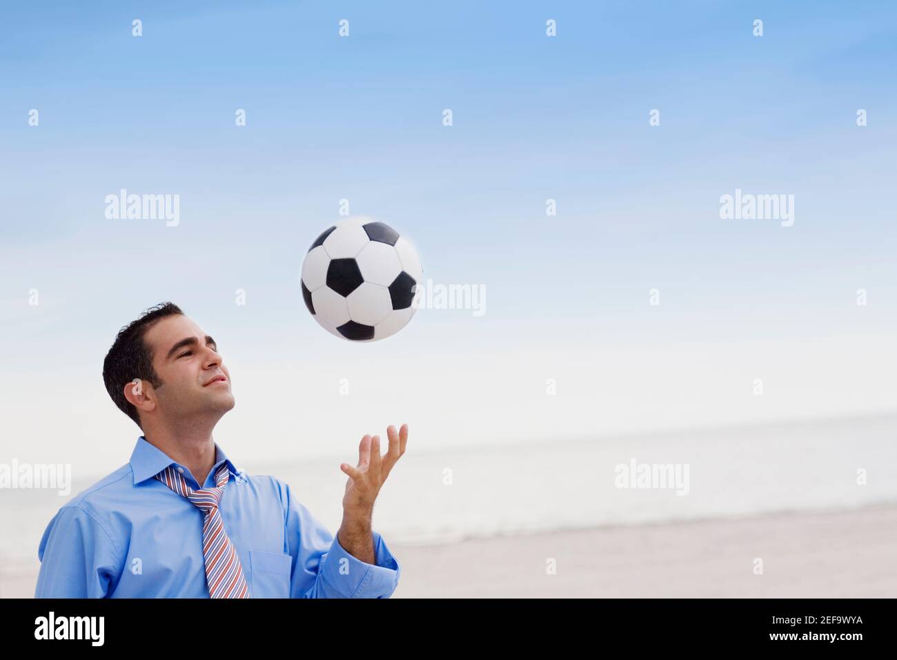 Gros plan d'un jeune homme jouant avec un ballon de football Banque D'Images