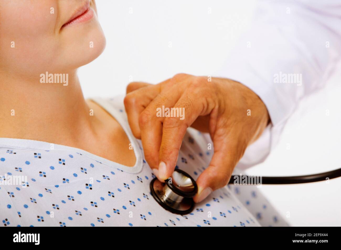 Gros plan d'une main mâle d'un doctorÅtv examinant une patiente avec un stéthoscope Banque D'Images