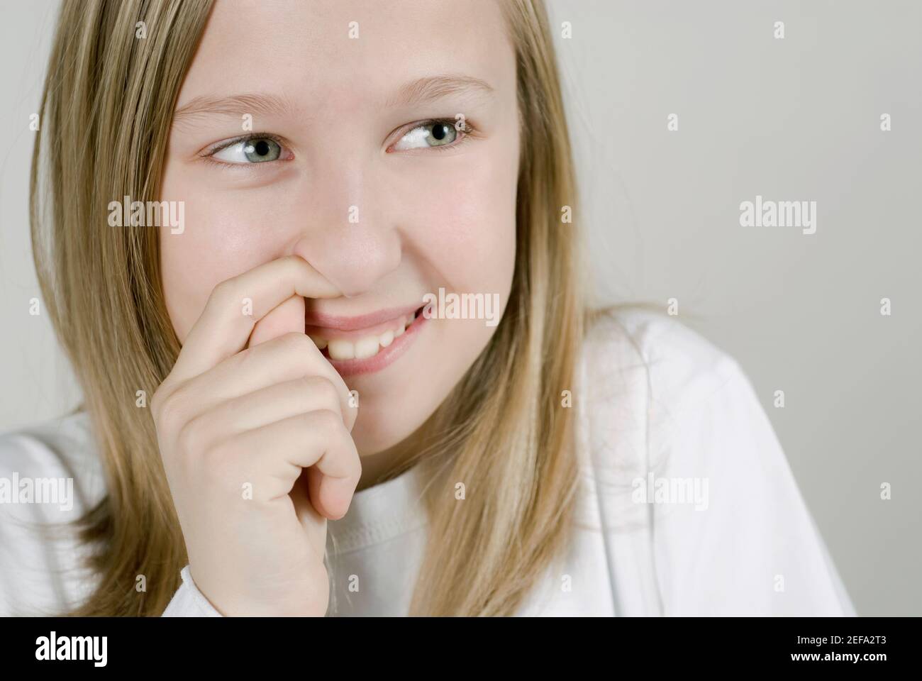 Gros plan d'une fille avec son doigt dans son nez Banque D'Images