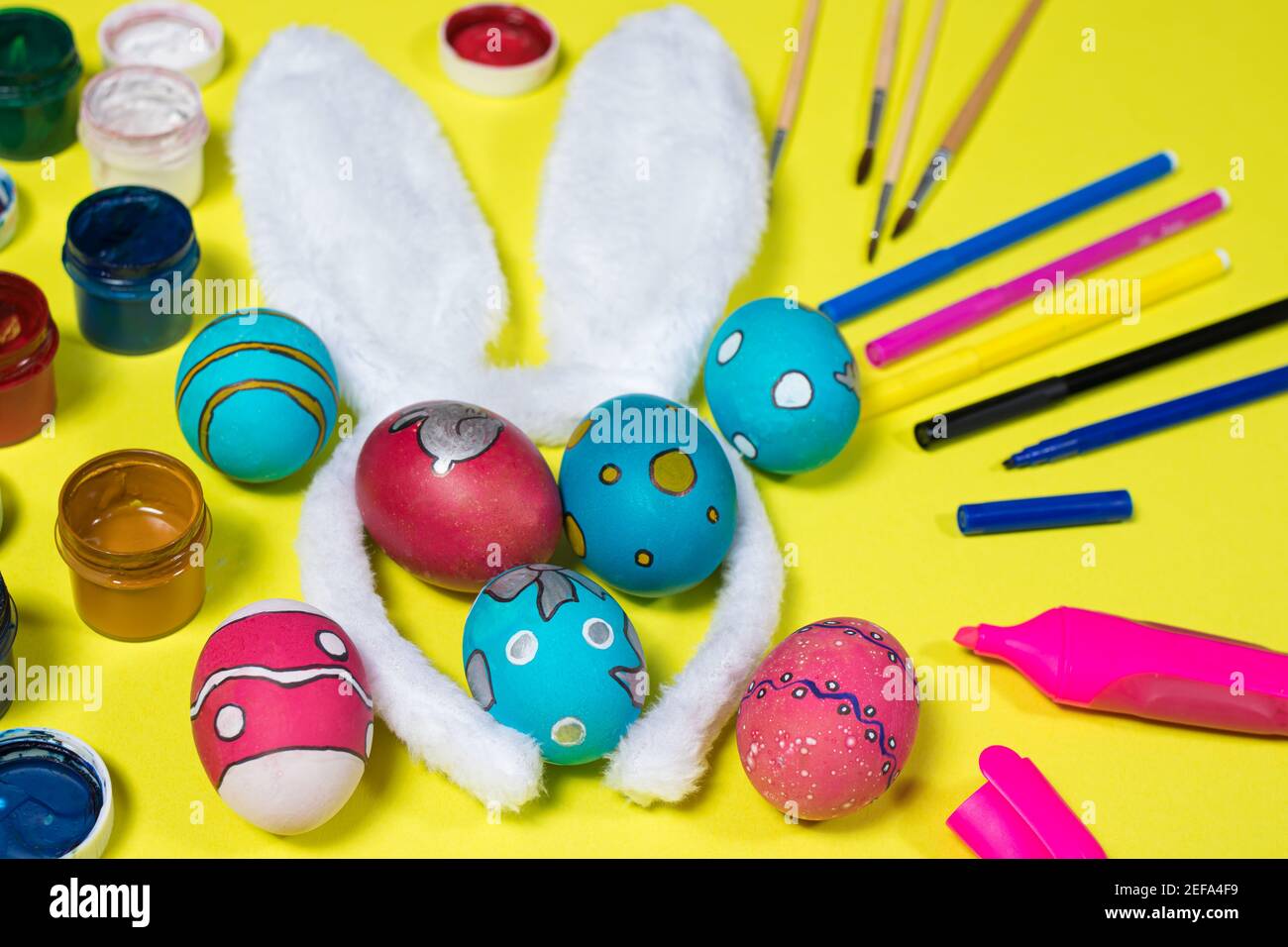 Concept de Pâques : oreilles de lapin, œufs peints, peintures