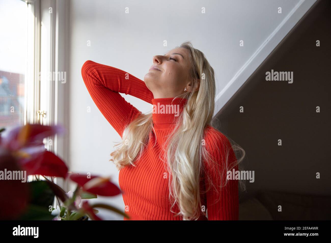 Elle s'étire le dos, elle se sent bonne, saine et positive. Elle est à la maison et c'est l'hiver Banque D'Images