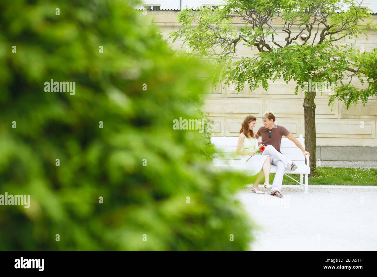 Jeune couple assis sur un banc Banque D'Images