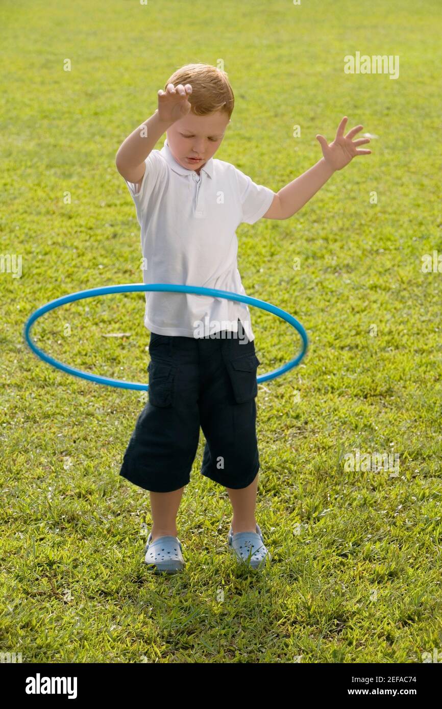 Garçon jouant avec un panier en plastique dans un parc Banque D'Images