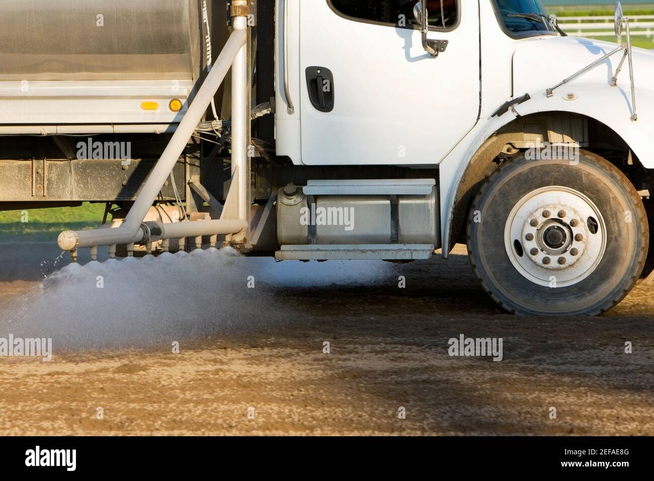 Chariot pulvérisant de l'eau sur une piste de course Banque D'Images