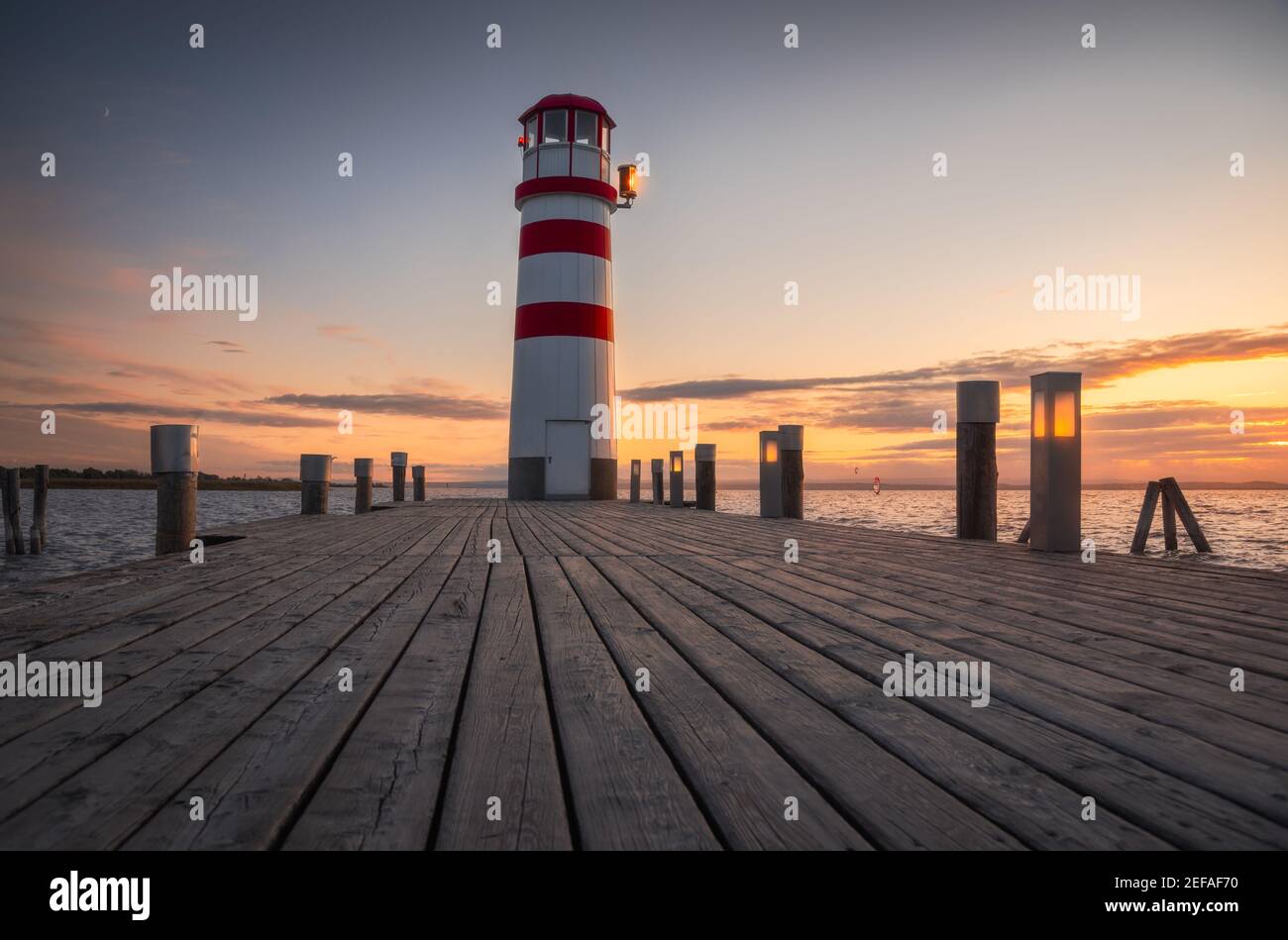 Jetée en bois sous le phare sur le lac Neusiedl, Autriche au coucher du soleil Banque D'Images