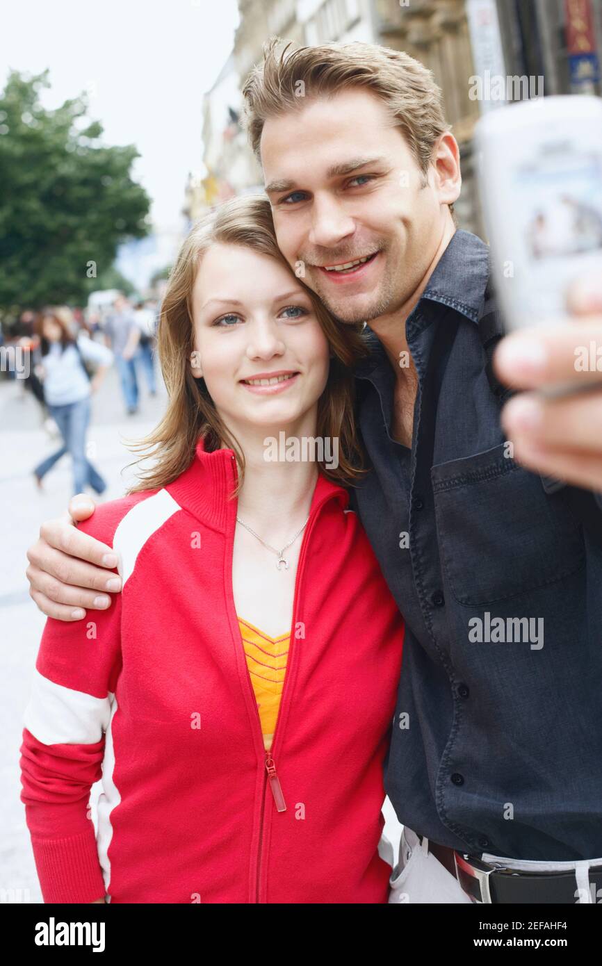 Couple adolescent tenant un téléphone portable pour une photo Banque D'Images