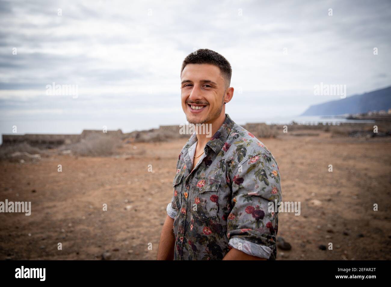 Portrait d'un jeune garçon européen souriant. Il est très heureux et porte une chemise avec des roses Banque D'Images