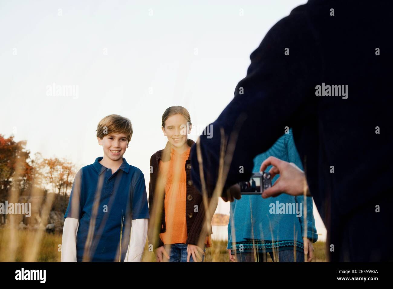 Vue arrière d'un homme qui photographie sa famille Banque D'Images