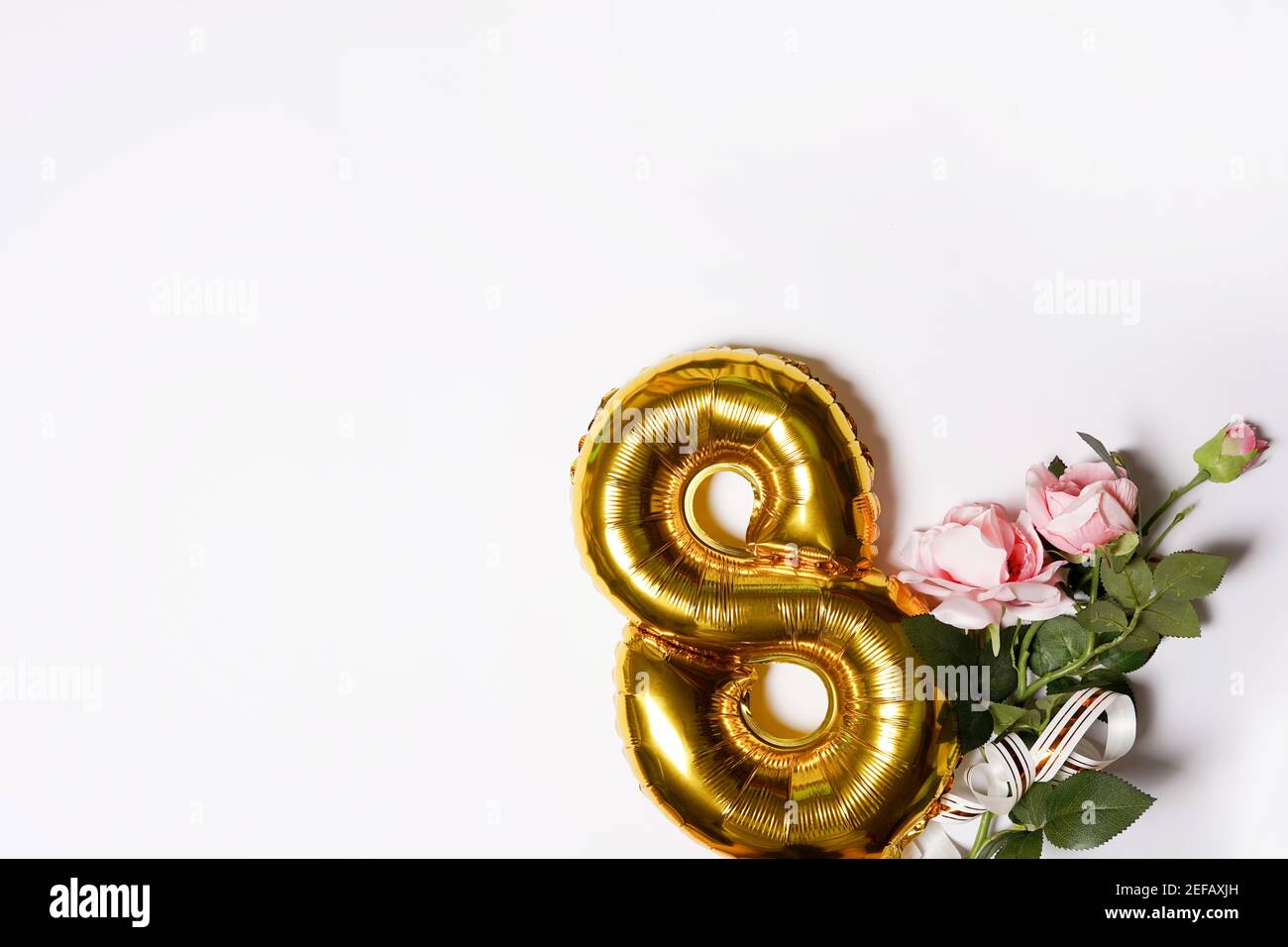 8 numéro doré ballon avec roses roses de fleur rose. fond blanc avec copyspace. Vacances pour femmes et concept du 8 mars. Carte de vœux Banque D'Images