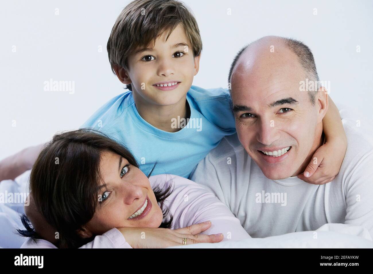 Portrait d'un garçon et de ses parents allongé sur le lit Banque D'Images