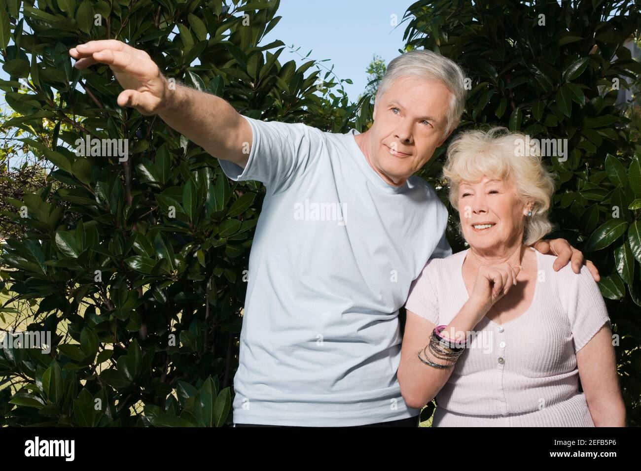 Couple senior debout dans un jardin Banque D'Images