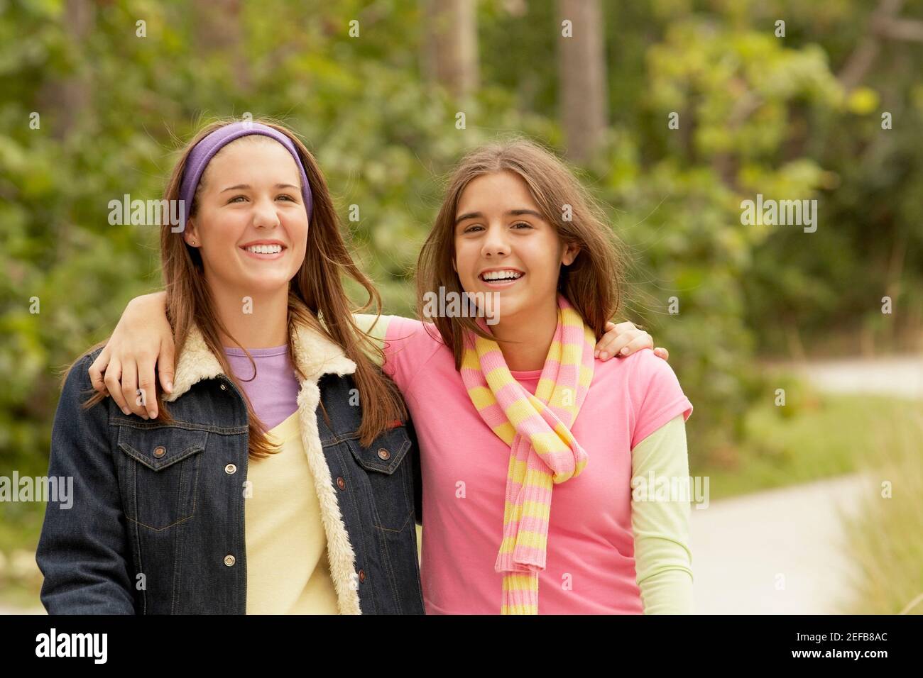 Portrait d'une fille avec son bras autour de son ami et souriant Banque D'Images