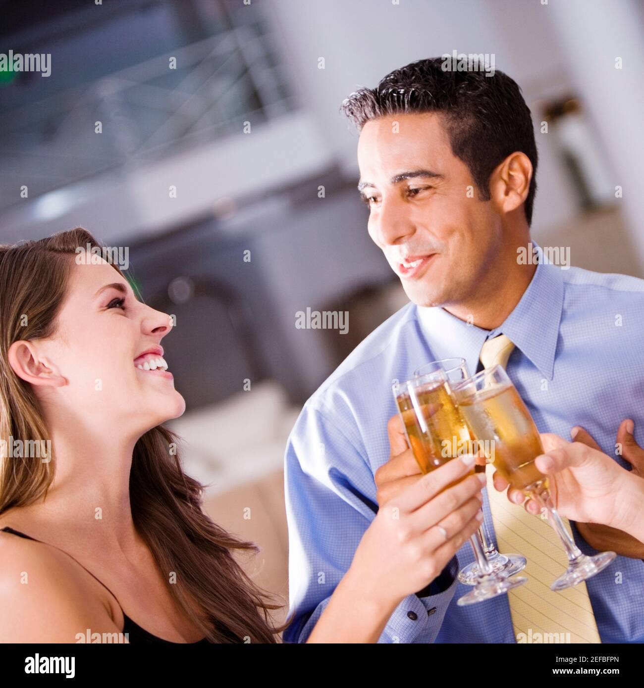 Homme adulte moyen et une jeune femme portant un toast Banque D'Images