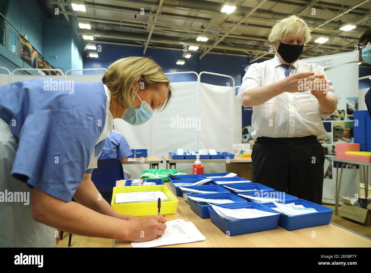 Le Premier ministre Boris Johnson s'entretient avec des travailleurs de la santé lors d'une visite dans un centre de vaccination Covid-19 au stade Cwmbran à Cwmbran, au sud du pays de Galles. Date de la photo: Mercredi 17 février 2021. Banque D'Images