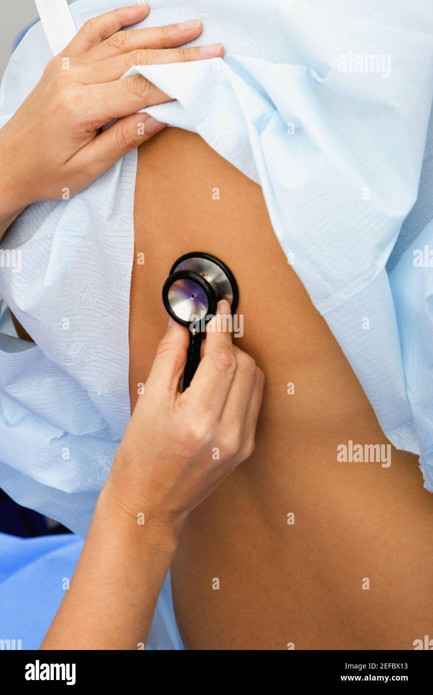 Gros plan d'une main de doctorÅthoscope tenant un stéthoscope et examinant un patient Banque D'Images