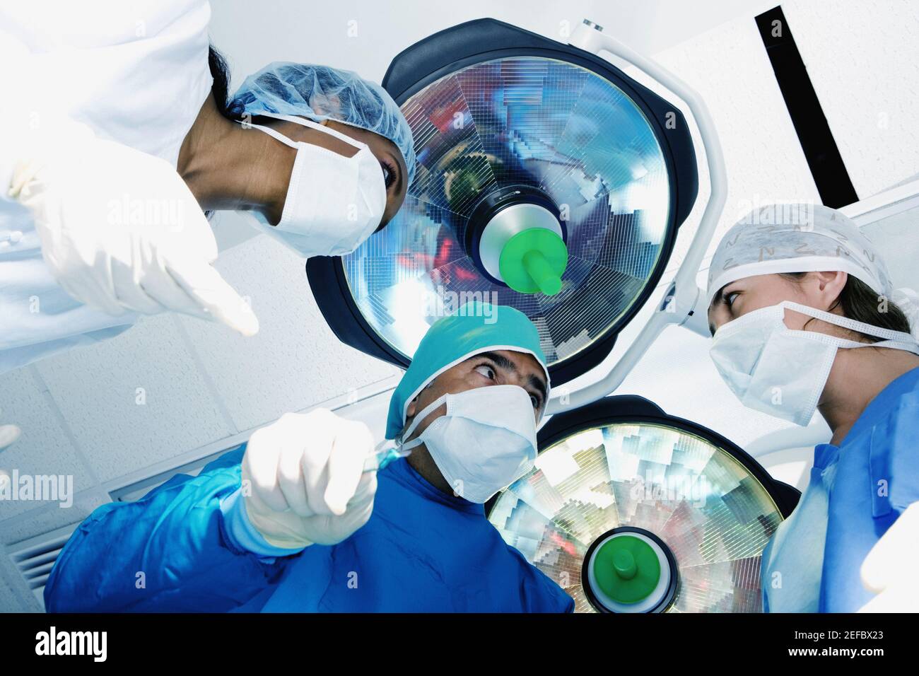 Chirurgien masculin et deux chirurgiens féminins dans une salle d'opération Banque D'Images