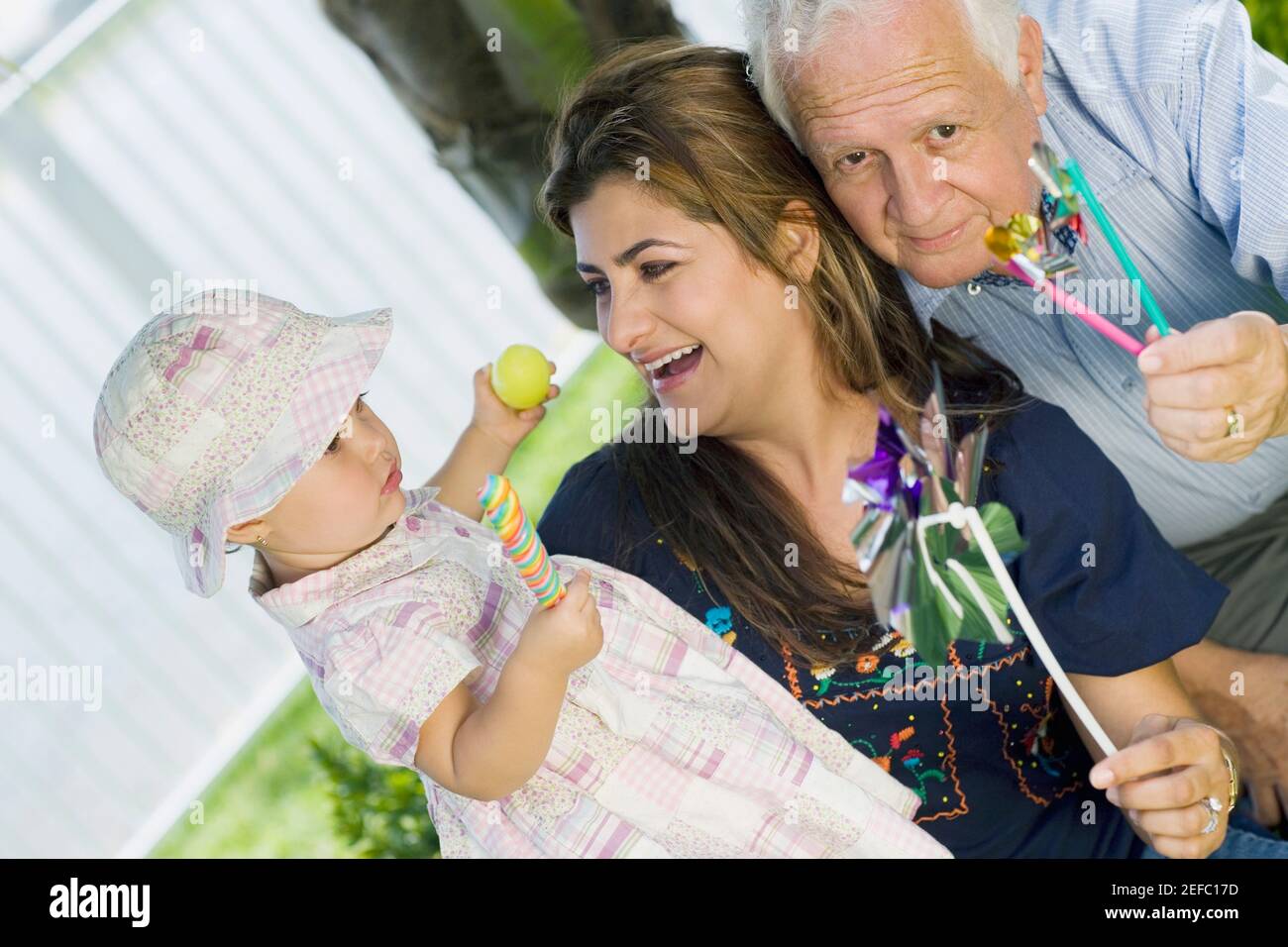 Fille tenant un bonbon avec sa mère et grand-père Banque D'Images