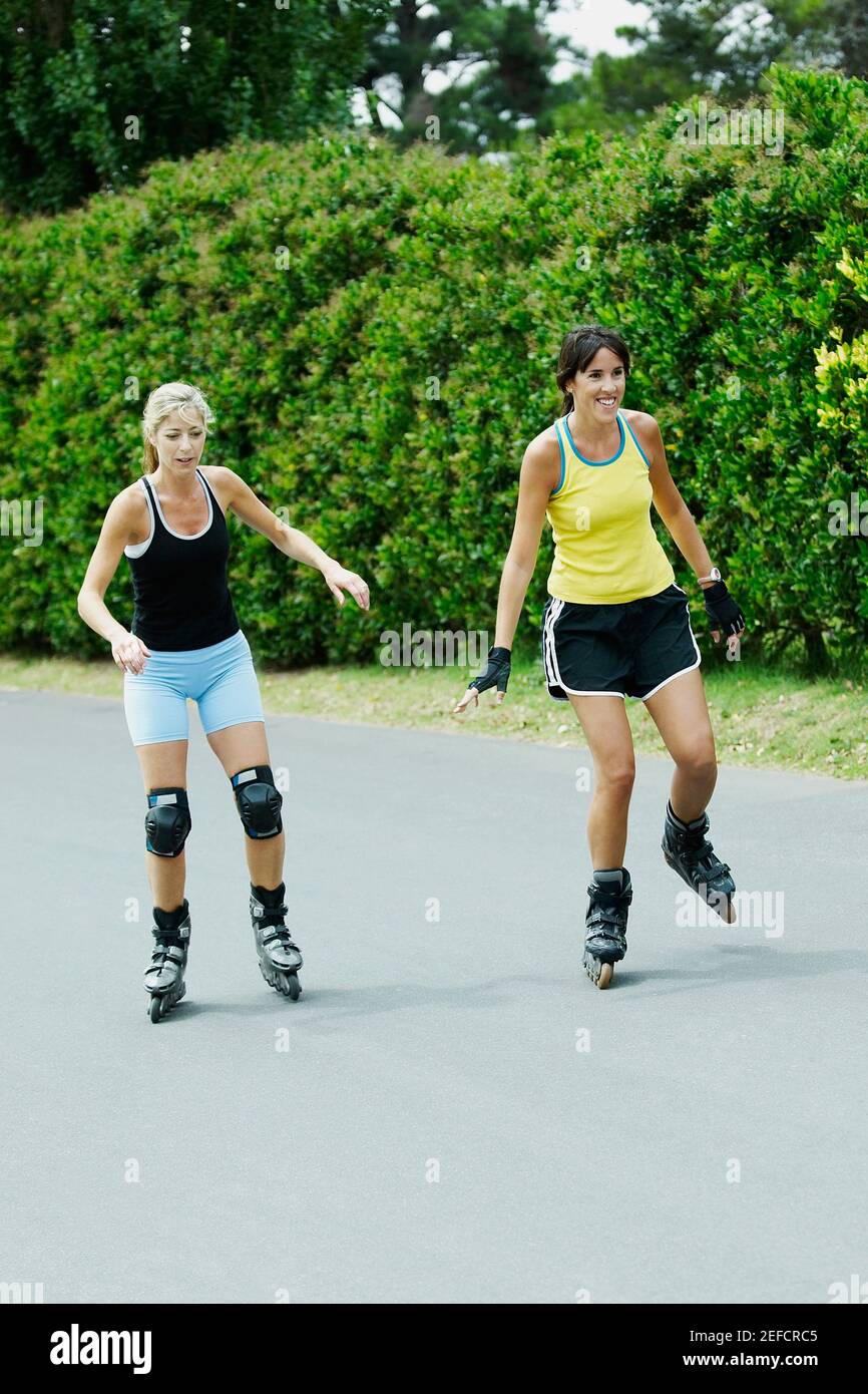 Deux femmes de taille moyenne patineuses en ligne Banque D'Images