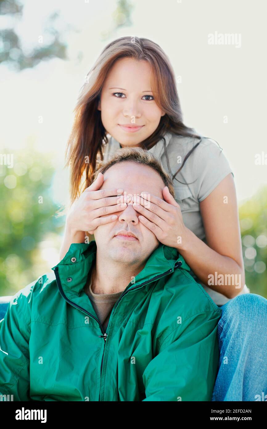 Portrait d'une jeune femme couvrant un homme adulte moyen yeux Banque D'Images