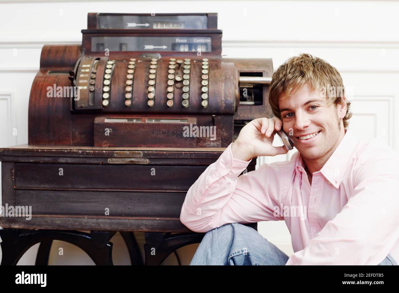 Portrait d'un jeune homme parlant sur un téléphone portable près d'une machine à écrire Banque D'Images
