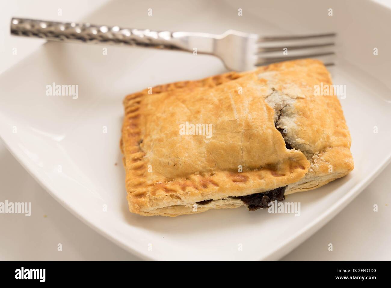 Tranche de tarte au bœuf sur plaque en céramique blanche Banque D'Images