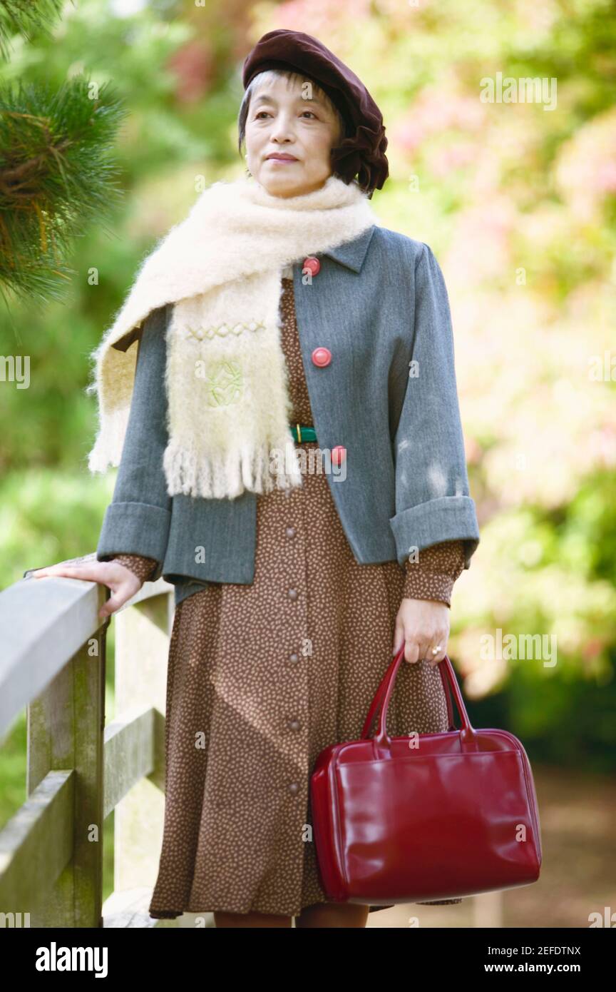 Femme mature debout tenant un sac Banque D'Images