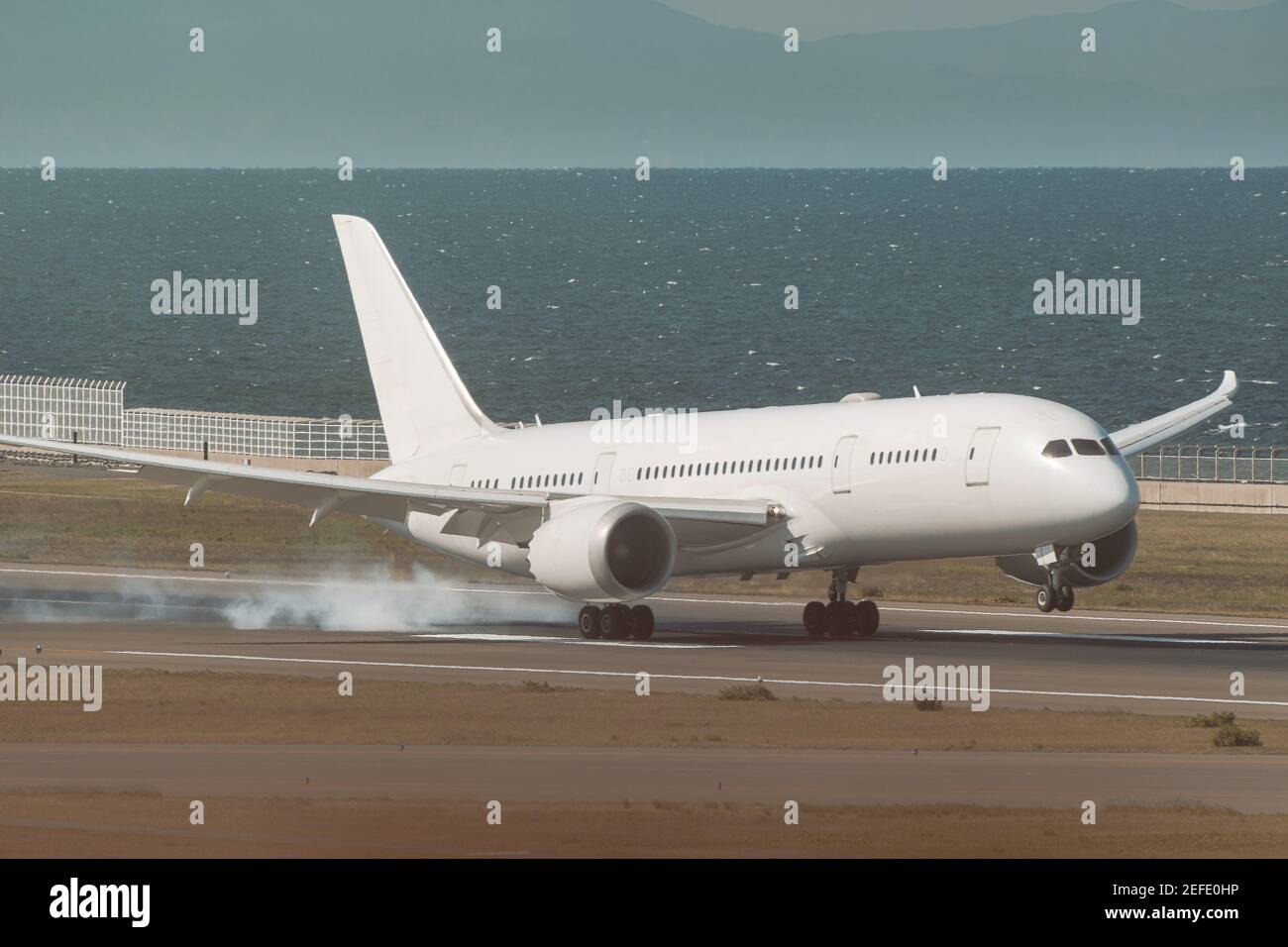 atterrissage en avion blanc dans l'après-midi de brume avec fond d'océan Banque D'Images