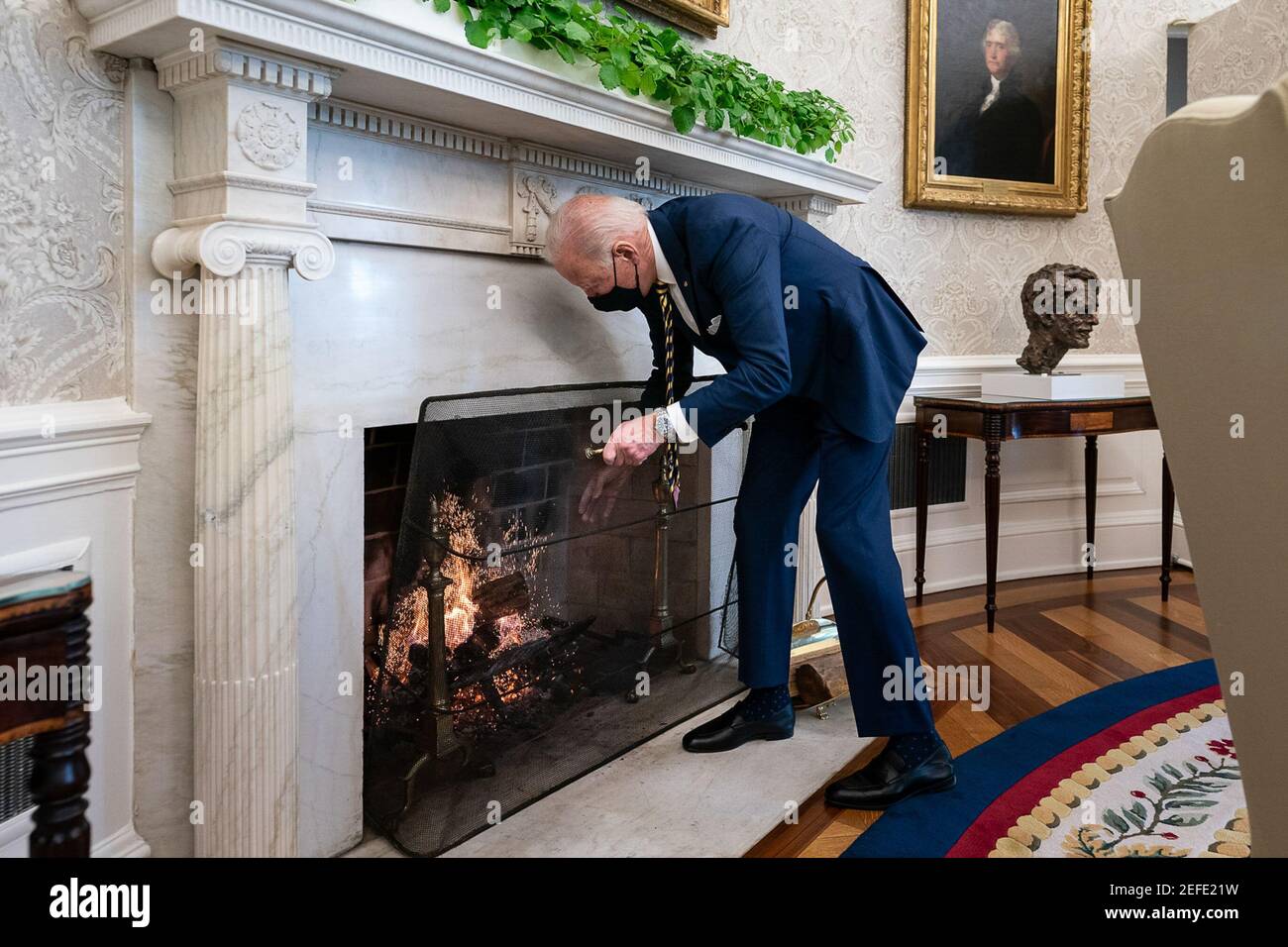 Le président Joe Biden ajoute un journal au feu dans le bureau ovale de la Maison Blanche le vendredi 22 janvier 2021. Banque D'Images