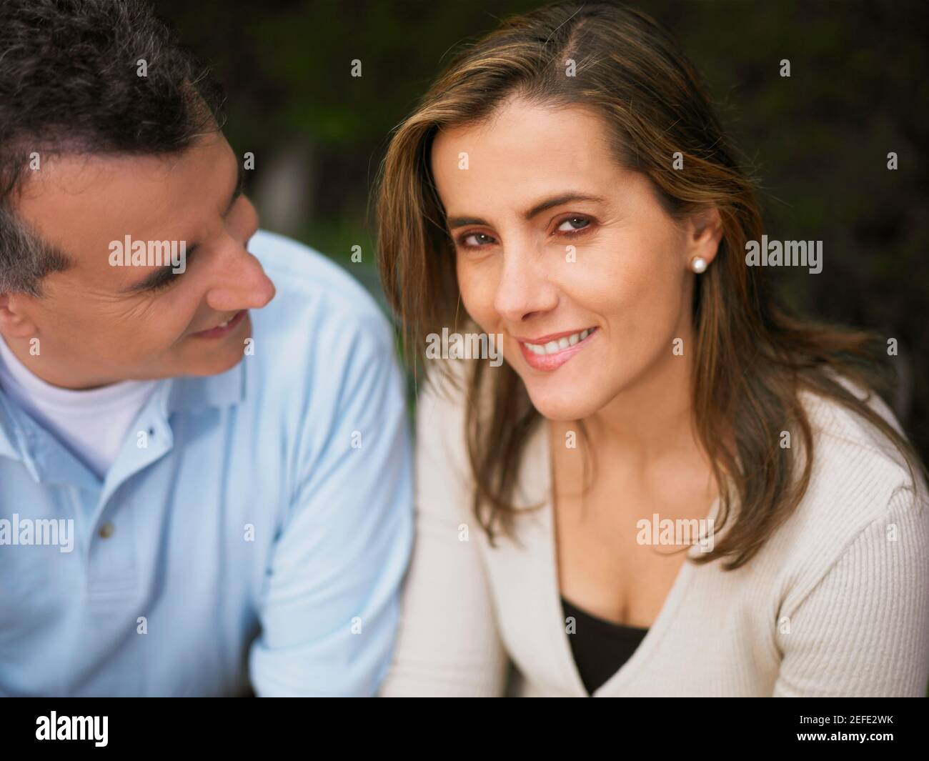 Portrait d'une femme adulte de taille moyenne souriant et mature homme la regardant Banque D'Images