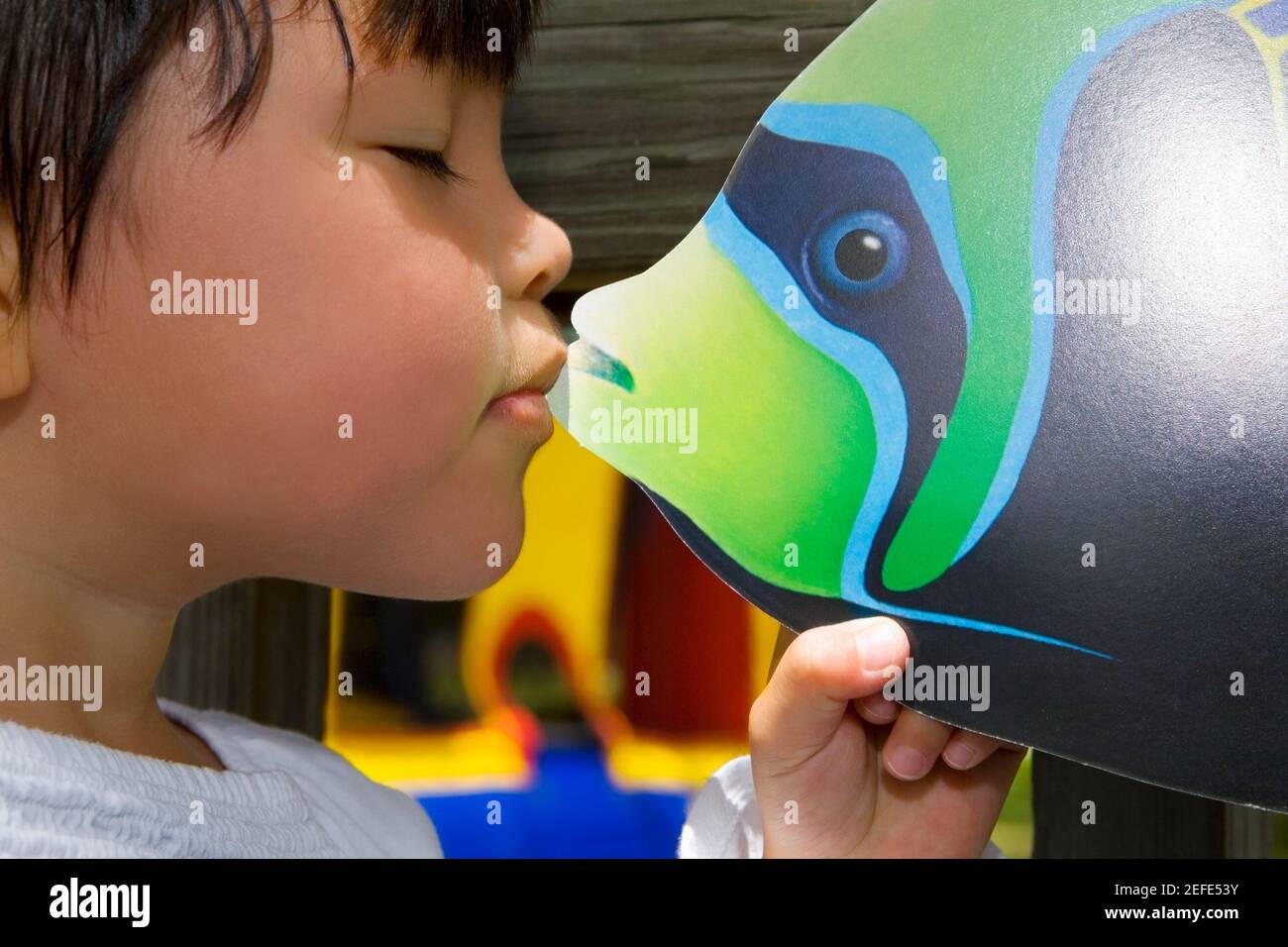 Gros plan d'une fille embrassant un jouet de poisson Banque D'Images