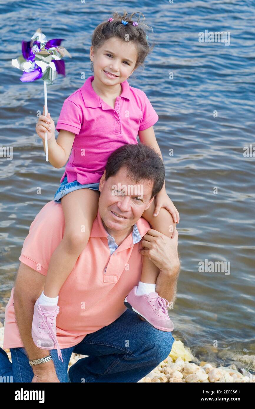 Homme adulte moyen portant sa fille sur ses épaules à Le bord de l'eau Banque D'Images