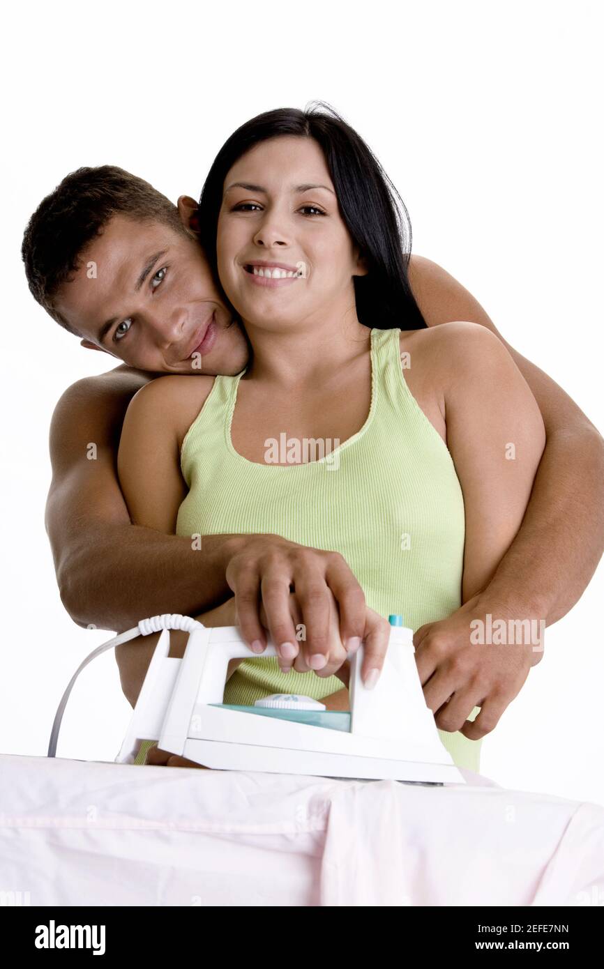Portrait d'un jeune couple repassant sur une planche à repasser Banque D'Images