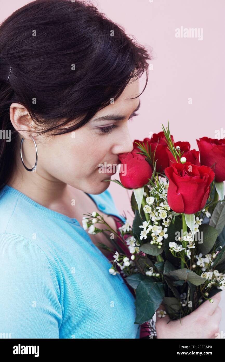 Gros plan d'une jeune femme tenant un bouquet de roses Banque D'Images