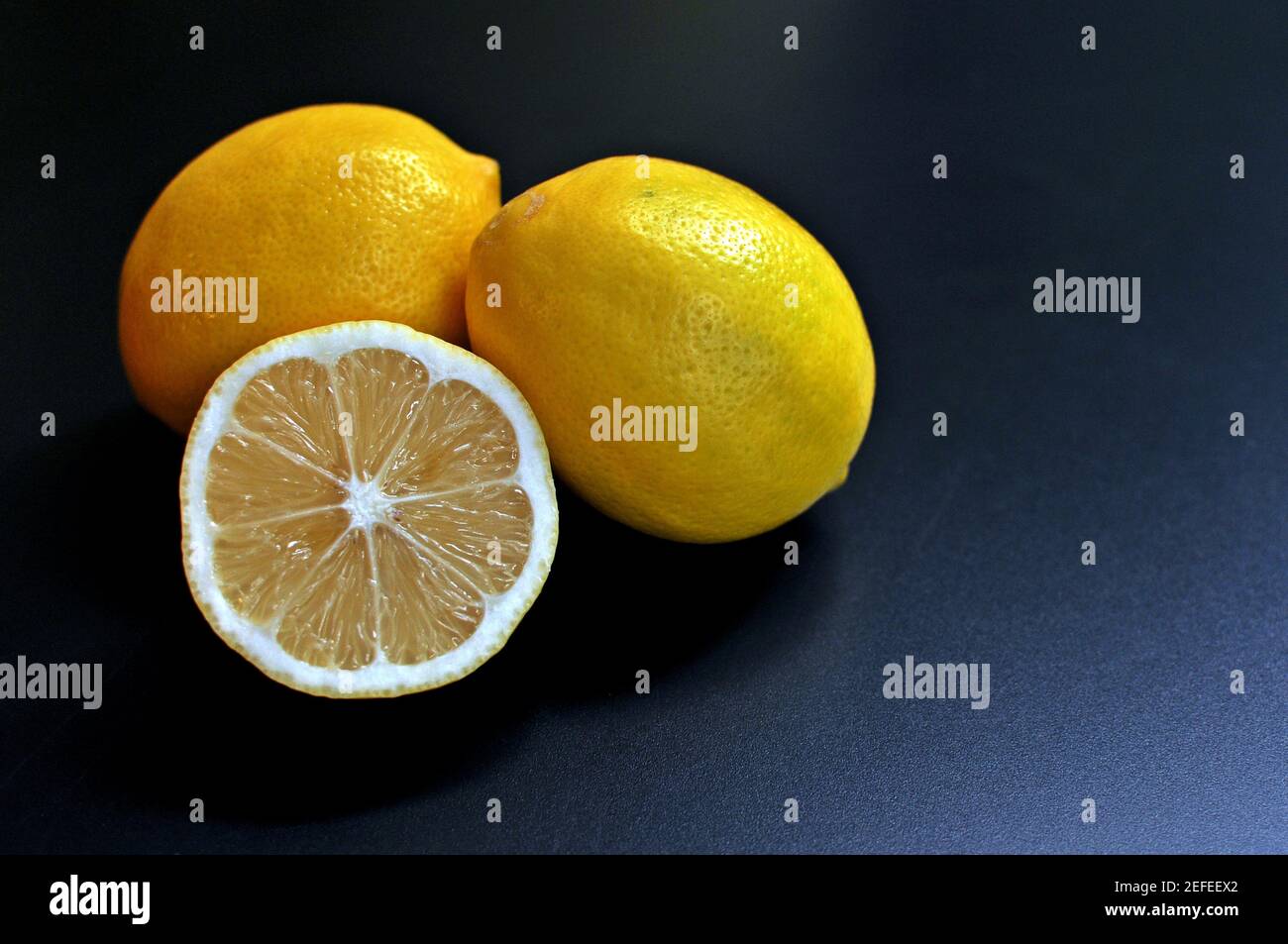 Concept de trois citrons, deux entiers et un demi sur fond noir. Copier le texte d'espace. Vue avant Banque D'Images