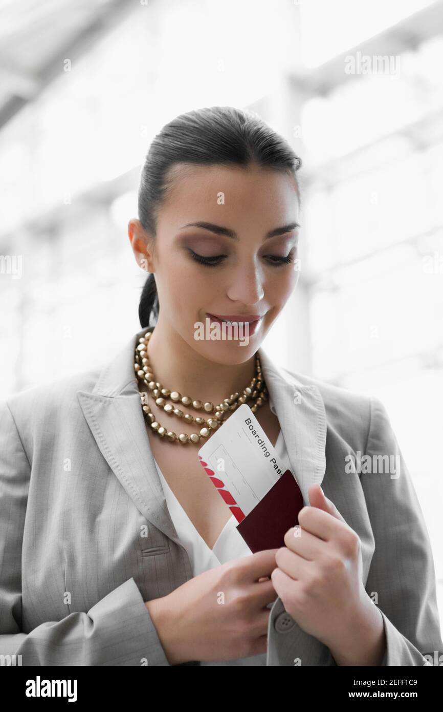Gros plan d'une femme d'affaires mettant un passeport et un avion billet dans sa poche Banque D'Images