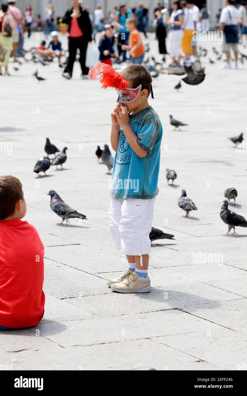 Profil latéral d'un garçon debout et portant un masque, Venise, Vénétie, Italie Banque D'Images