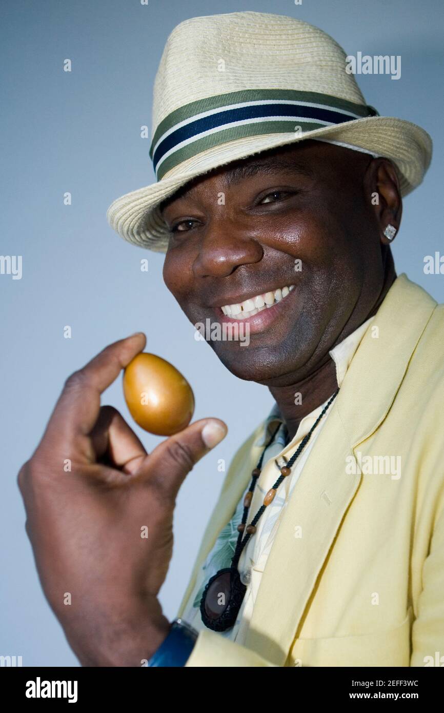Portrait d'un homme mature tenant un œuf doré Banque D'Images