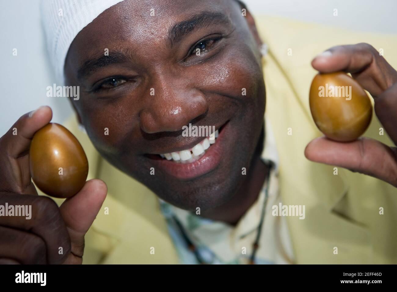 Portrait d'un homme mature tenant deux œufs d'or Banque D'Images
