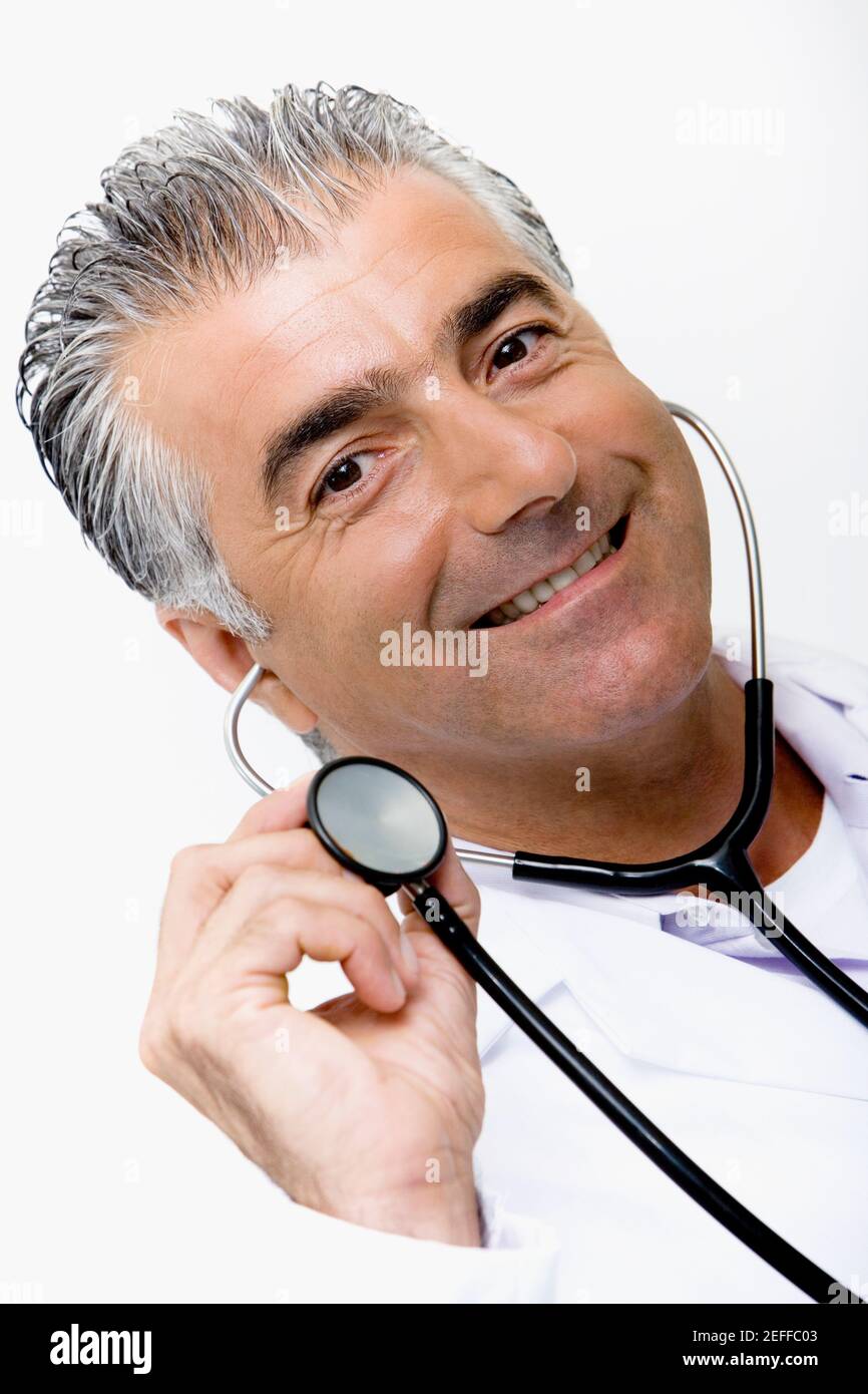 Portrait d'un médecin masculin tenant un stéthoscope et souriant Banque D'Images