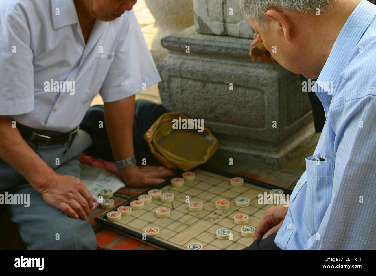 Deux hommes matures jouant un jeu de société, Hanoi, Vietnam Banque D'Images