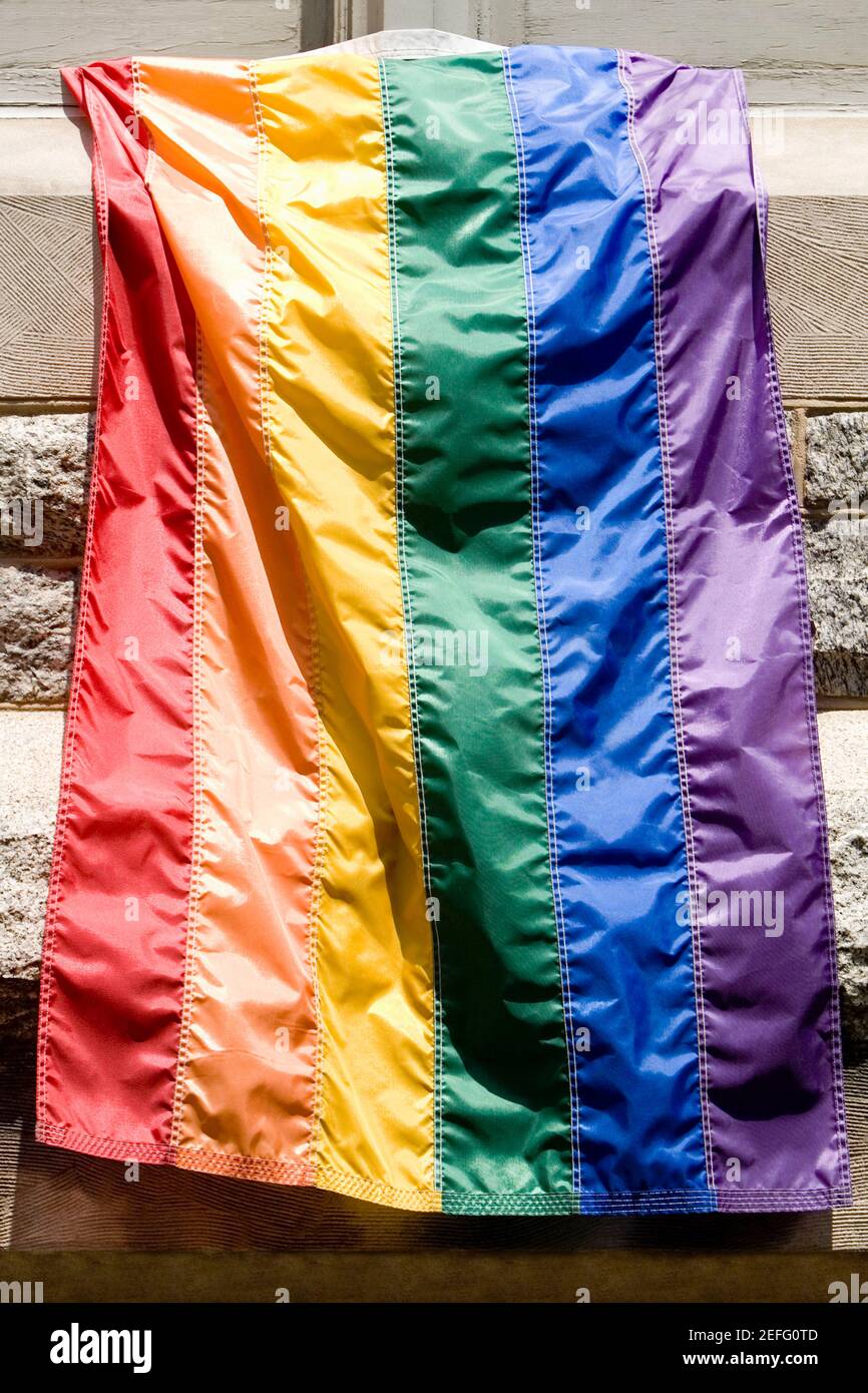 Drapeau arc-en-ciel suspendu sur une fenêtre d'un bâtiment Banque D'Images