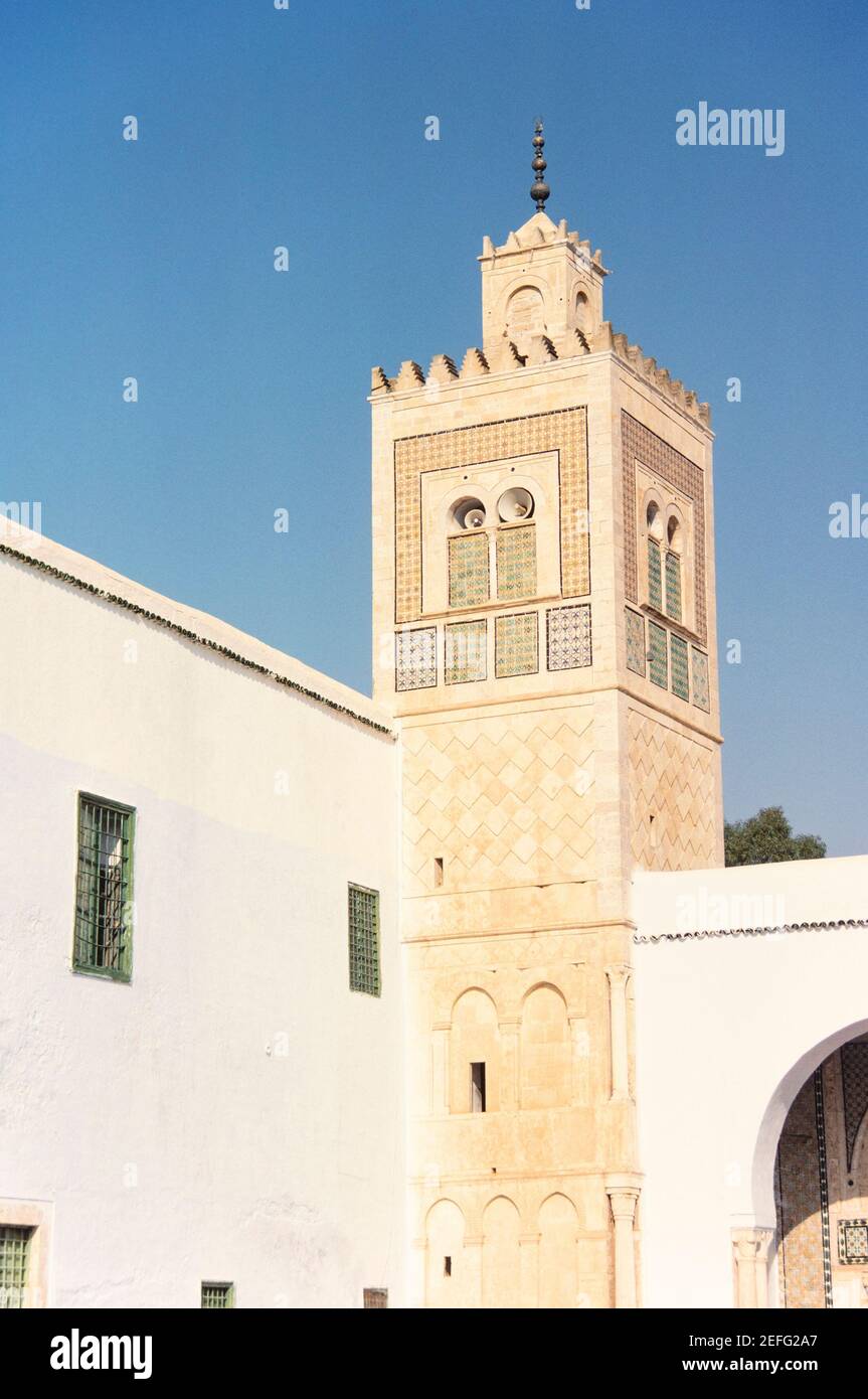1988 Kairouan Tunisie - la tour de cloche de la mosquée Sidi Sahbi, mosquée du Barbier, est aussi une école ou un monastère religieux islamique. Le mausolée de Sidi Sahab, généralement connu sous le nom de mosquée du Barbier, est en fait une zaouia située à l'intérieur des murs de la ville. Il a été construit par le Muradid Hammuda Pasha Bey (mausolée, dôme et cour) et Murad II Bey (minaret et madrasa). Dans son état actuel, le monument date du XVIIe siècle. Kairouan, Tunisie, Afrique du Nord Banque D'Images