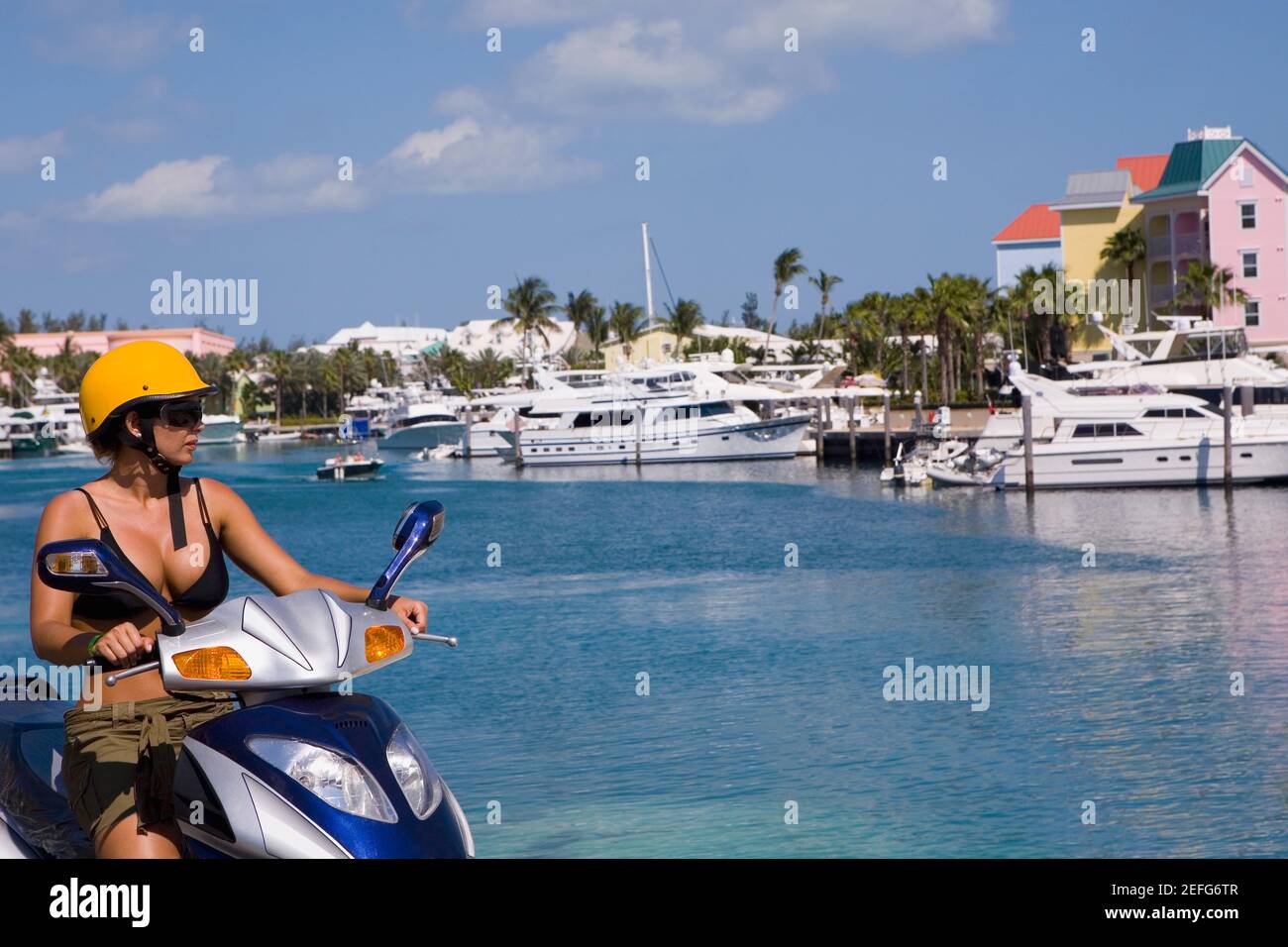 Femme adulte de taille moyenne conduisant un cyclomoteur, Paradise Island, Bahamas Banque D'Images